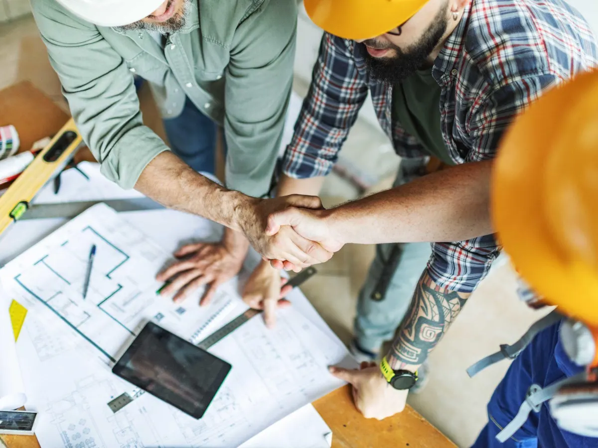 Contractors reviewing plans at a worksite